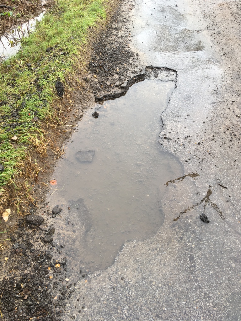 pothole on green lane from above